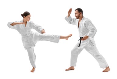 Photo of Man and woman in uniform practicing karate on white background