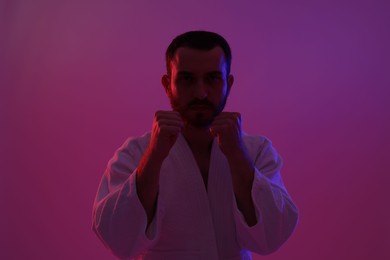 Photo of Karate fighter wearing uniform in color lights