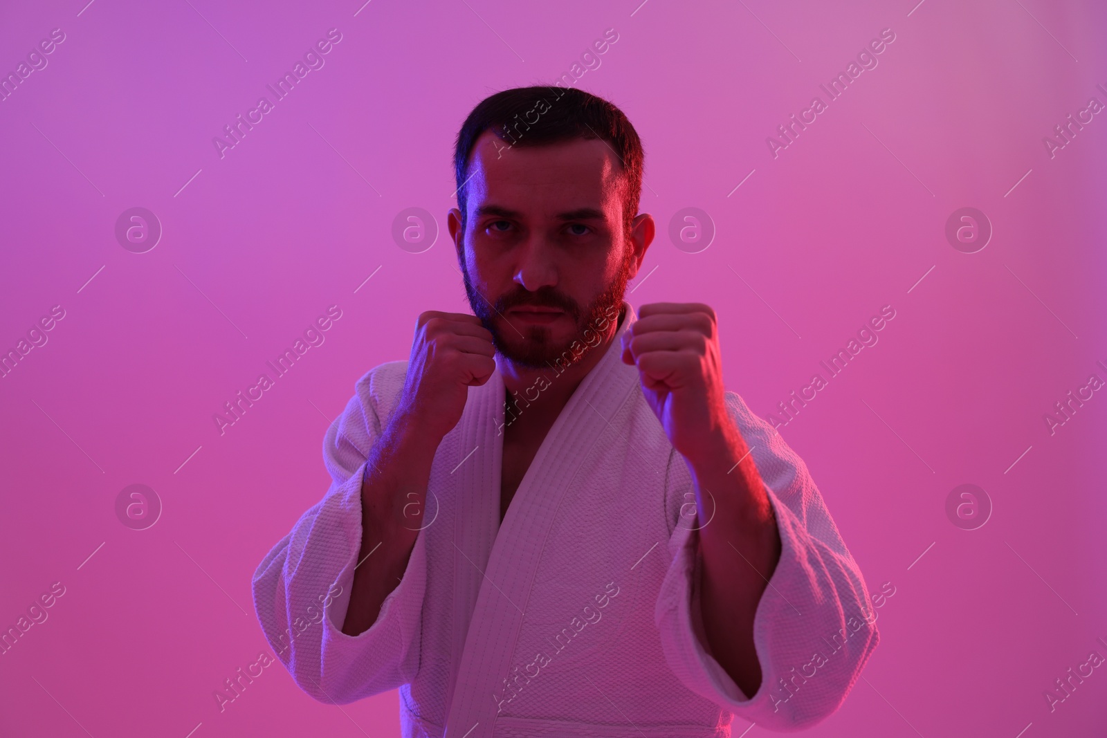 Photo of Karate fighter wearing uniform in color lights