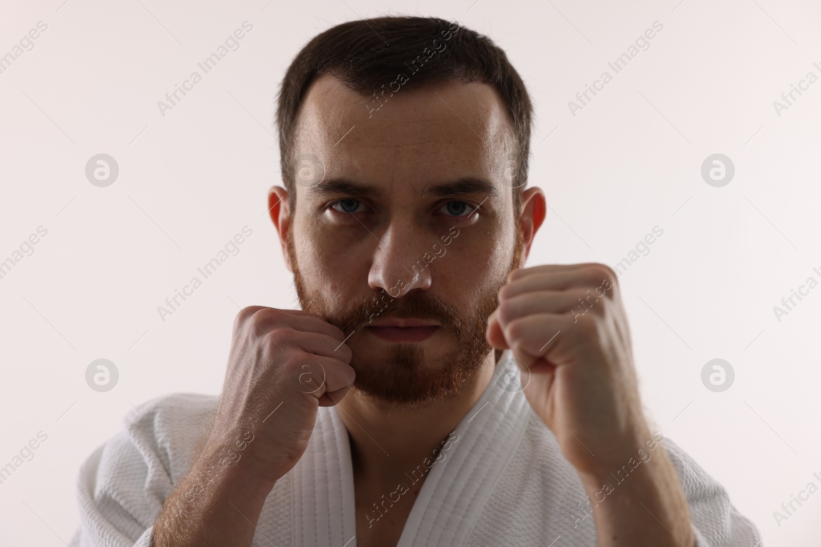 Photo of Karate fighter in uniform on white background