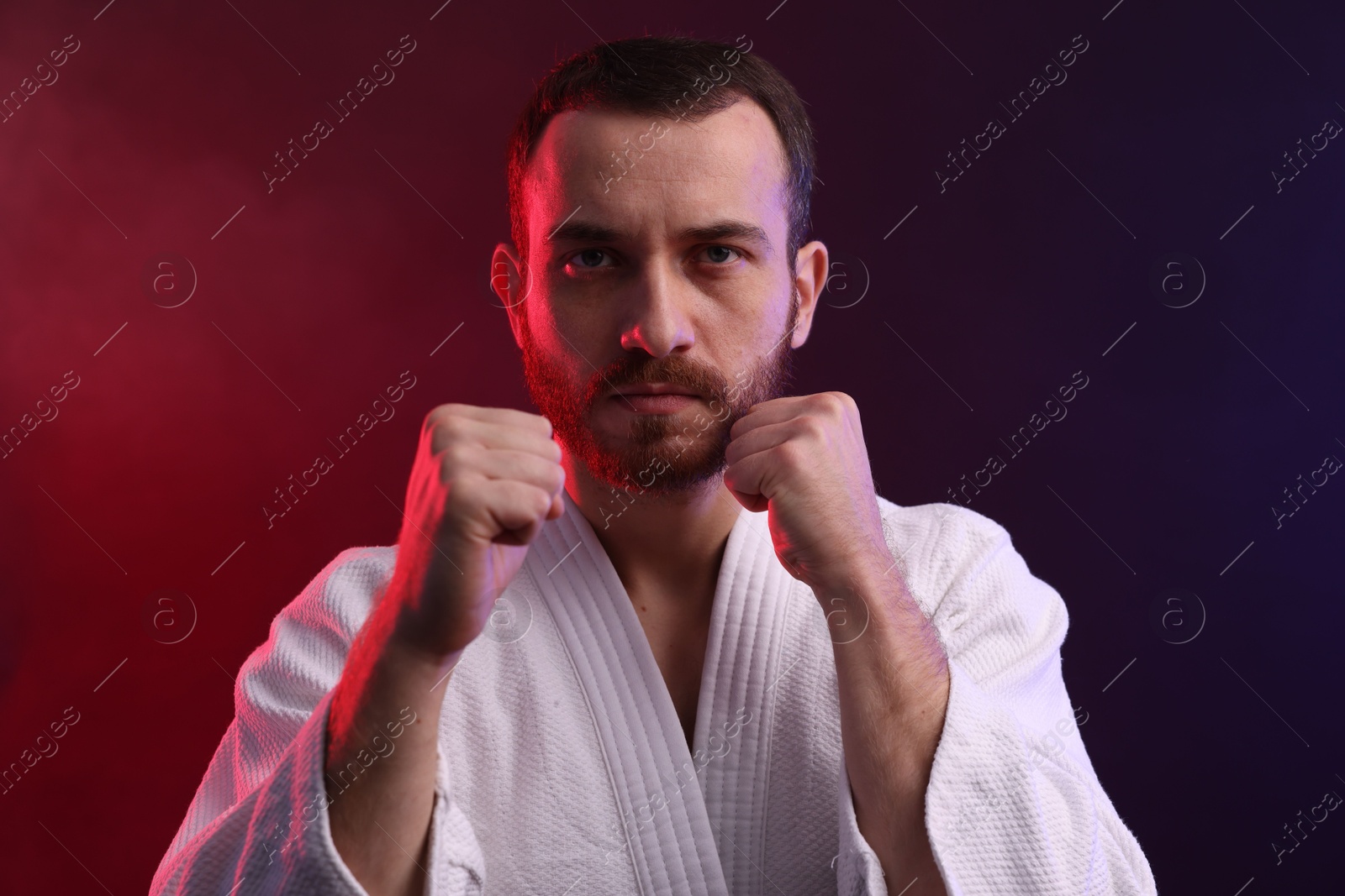 Photo of Karate fighter wearing uniform in color lights