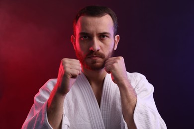 Photo of Karate fighter wearing uniform in color lights