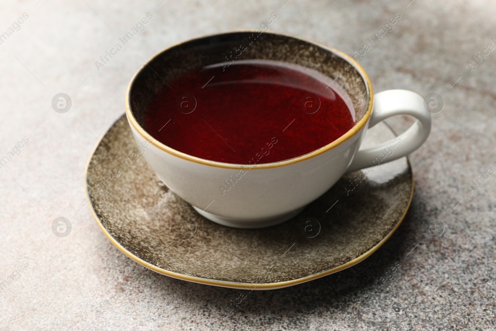 Photo of Aromatic tea in cup on light grey table, closeup