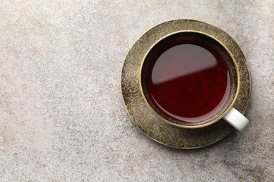 Photo of Aromatic tea in cup on light grey table, top view. Space for text