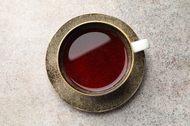 Photo of Aromatic tea in cup on light grey table, top view