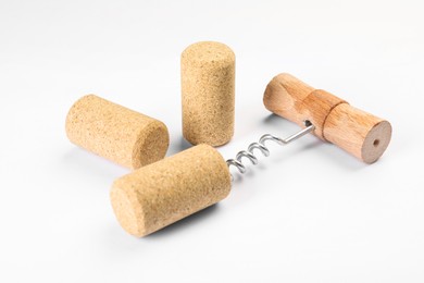 Photo of Corkscrew with wooden handle and corks on white background