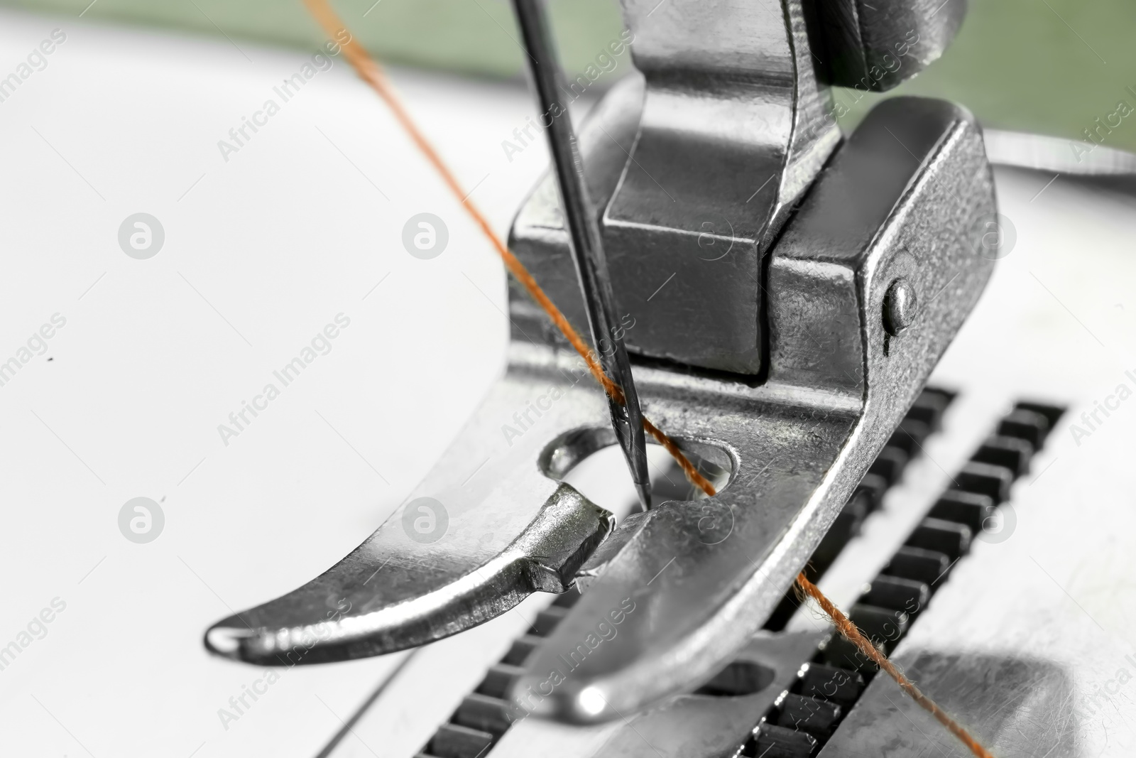 Photo of Sewing machine with thread on white background, macro view