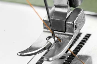 Photo of Sewing machine with thread on white background, macro view