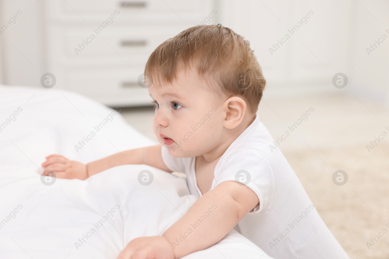 Photo of Sweet little baby near bed at home