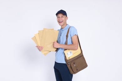 Photo of Happy postman with bag and envelopes on white background