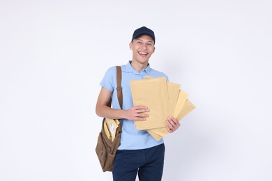 Photo of Happy postman with bag and envelopes on white background