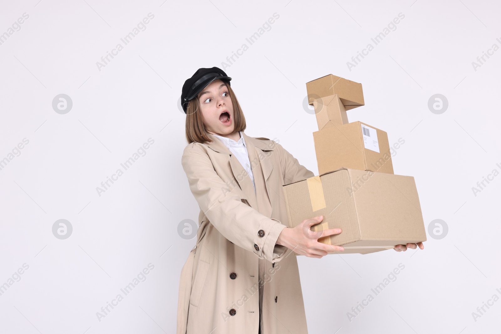 Photo of Emotional postwoman with parcels on white background. Space for text