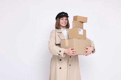 Photo of Happy postwoman with parcels on white background. Space for text