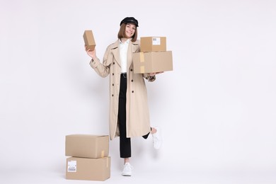 Photo of Happy postwoman with parcels on white background