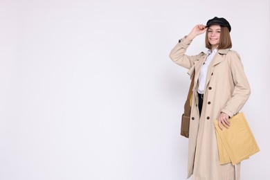 Photo of Happy postwoman with bag and envelopes on white background. Space for text