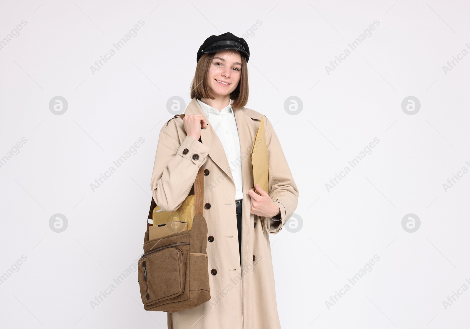 Photo of Happy postwoman with bag and envelopes on white background