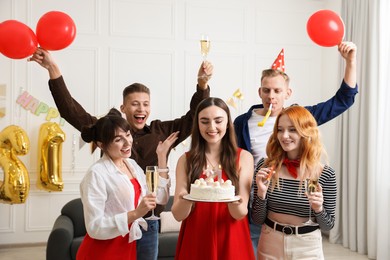 Photo of 21st birthday. Group of happy friends with tasty cake having coming of age party at home