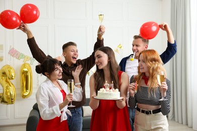 Photo of 21st birthday. Group of happy friends with tasty cake having coming of age party at home