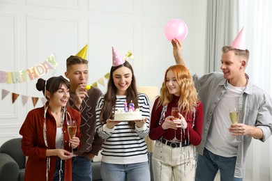 Photo of 18th birthday. Group of happy friends with tasty cake having coming of age party at home