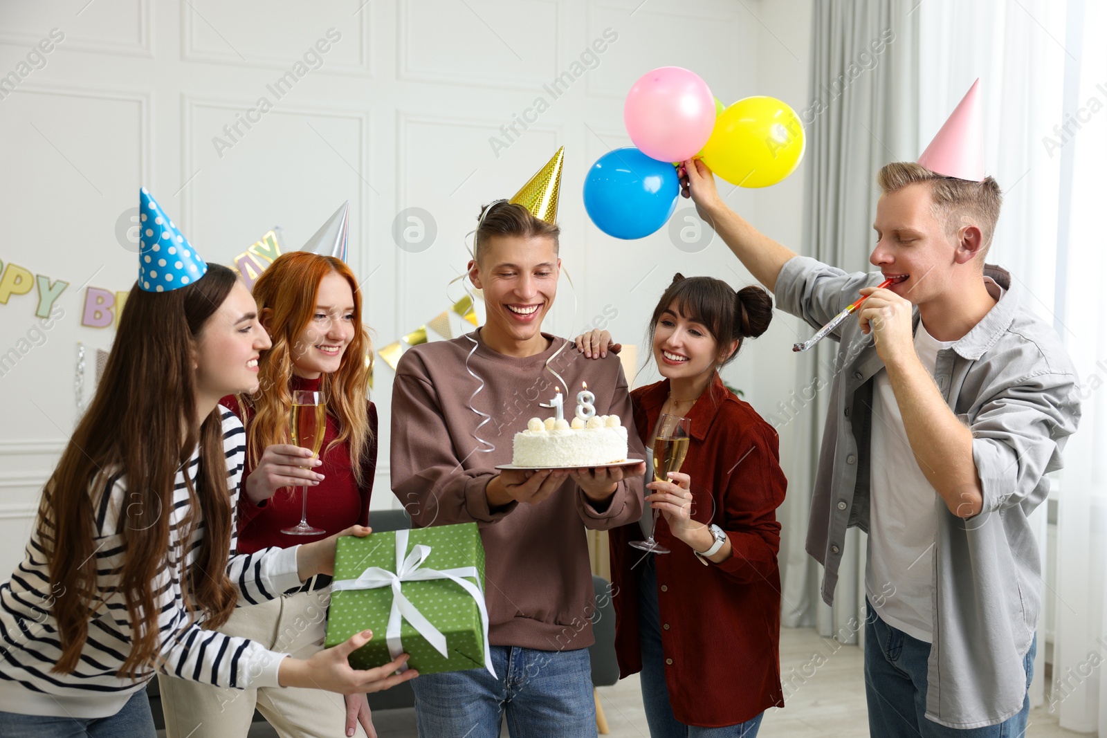 Photo of 18th birthday. Group of friends with tasty cake having coming of age party at home