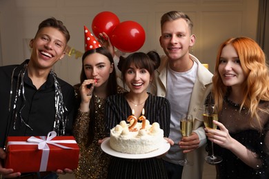 Photo of 21st birthday. Group of happy friends with tasty cake having coming of age party at home