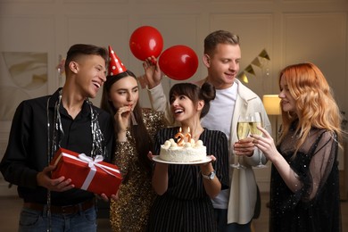 Photo of 21st birthday. Group of happy friends with tasty cake having coming of age party at home