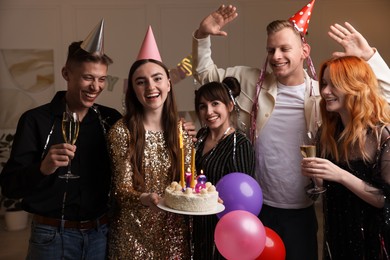 Photo of 18th birthday. Group of friends with tasty cake having coming of age party at home