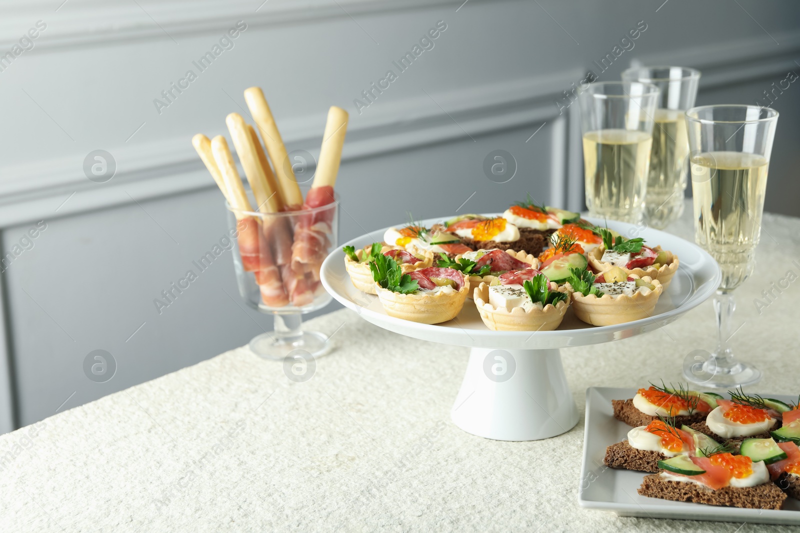 Photo of Many different tasty canapes and wine on white table