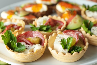 Photo of Many different tasty canapes on stand, closeup