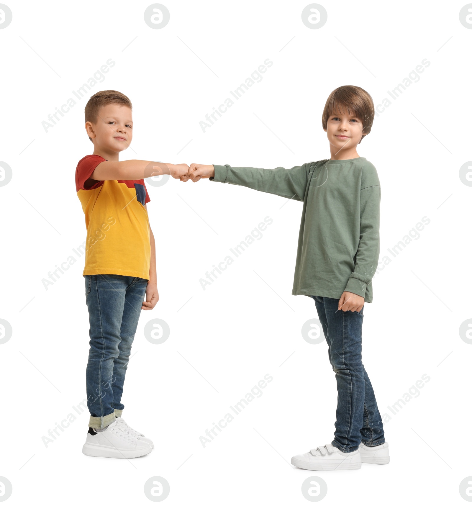 Photo of Cute brothers making fist bump on white background