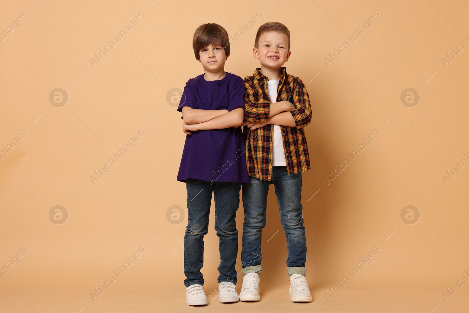 Photo of Full length portrait of cute brothers on beige background