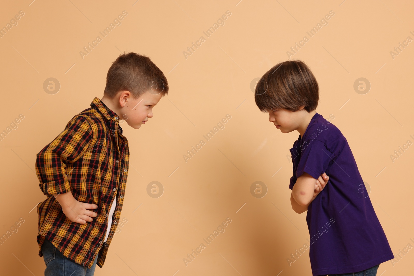 Photo of Angry brothers having argument on beige background