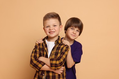 Photo of Portrait of cute brothers on beige background