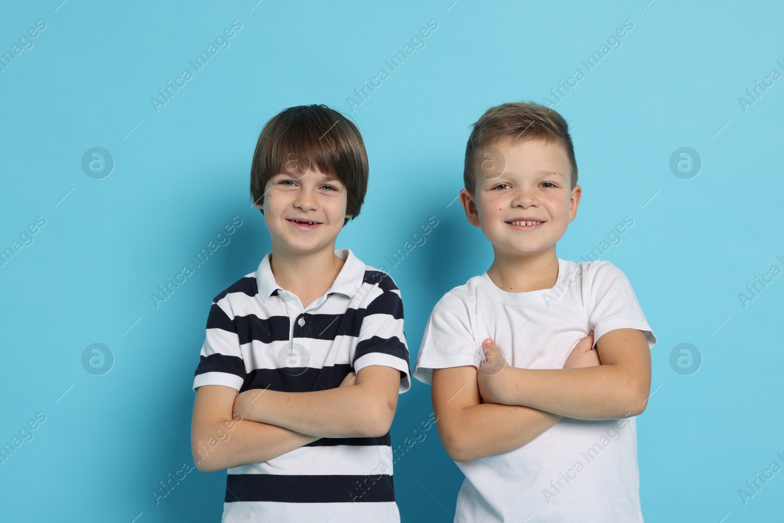 Photo of Portrait of cute brothers on light blue background