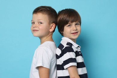 Portrait of cute brothers on light blue background