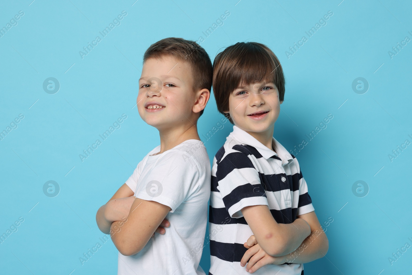 Photo of Portrait of cute brothers on light blue background