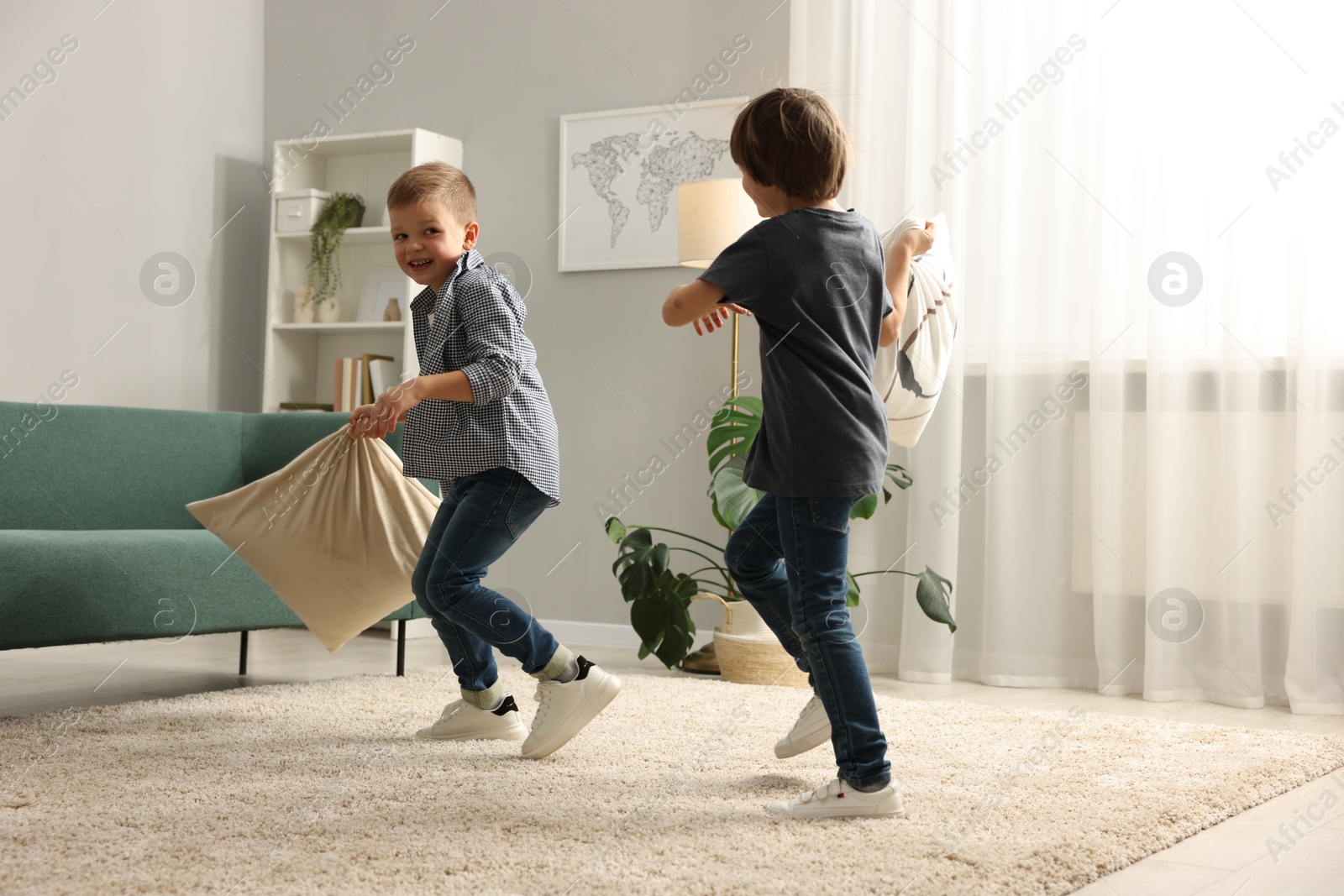 Photo of Brothers having fun pillow fight at home