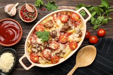 Photo of Delicious pasta casserole with cheese, tomatoes and minced meat in baking dish served on wooden table, flat lay