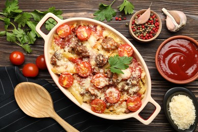 Photo of Delicious pasta casserole with cheese, tomatoes and minced meat in baking dish served on wooden table, flat lay