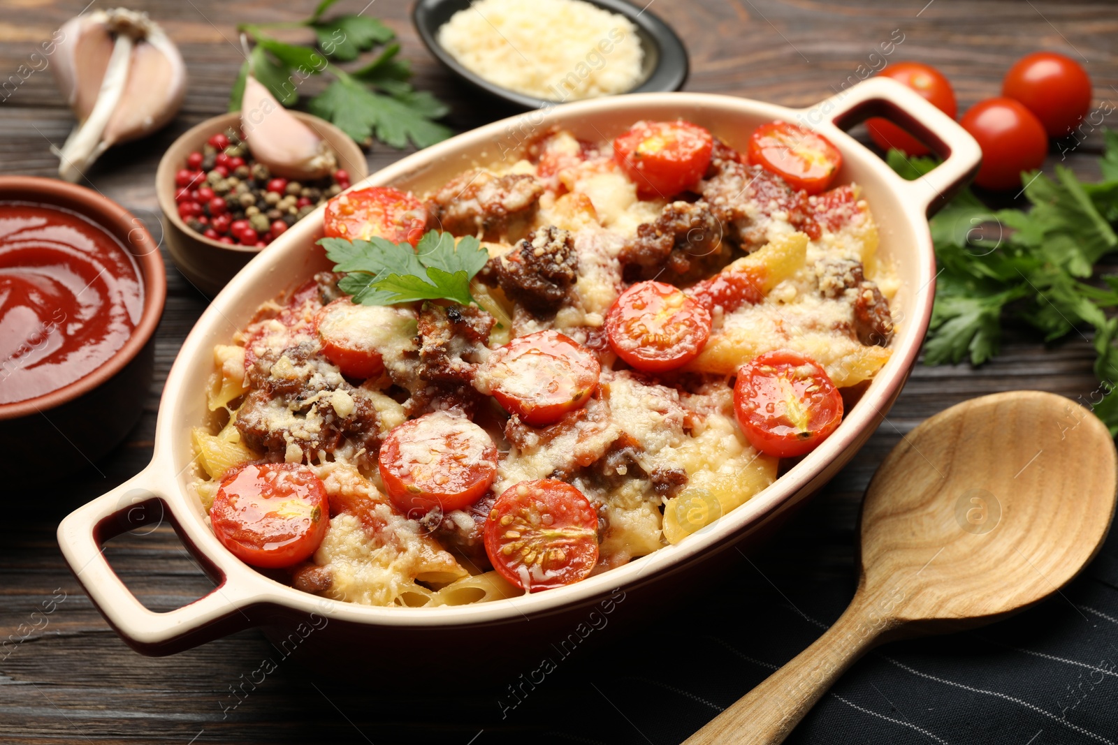 Photo of Delicious pasta casserole with cheese, tomatoes and minced meat in baking dish on wooden table, closeup