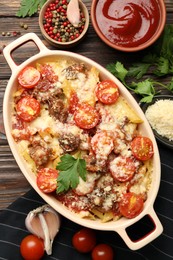 Photo of Delicious pasta casserole in baking dish with ingredients and sauce on wooden table, flat lay