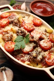 Photo of Delicious pasta casserole with cheese, tomatoes and minced meat in baking dish on table, closeup