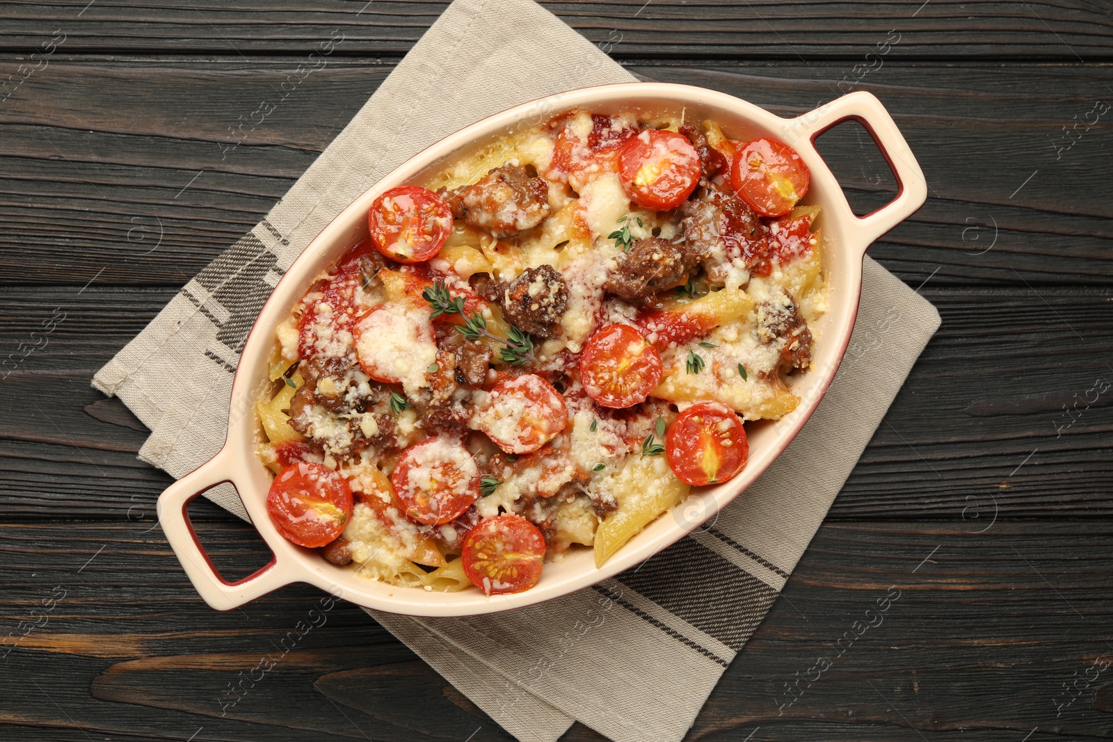 Photo of Delicious pasta casserole with cheese, tomatoes and minced meat in baking dish on wooden table, top view