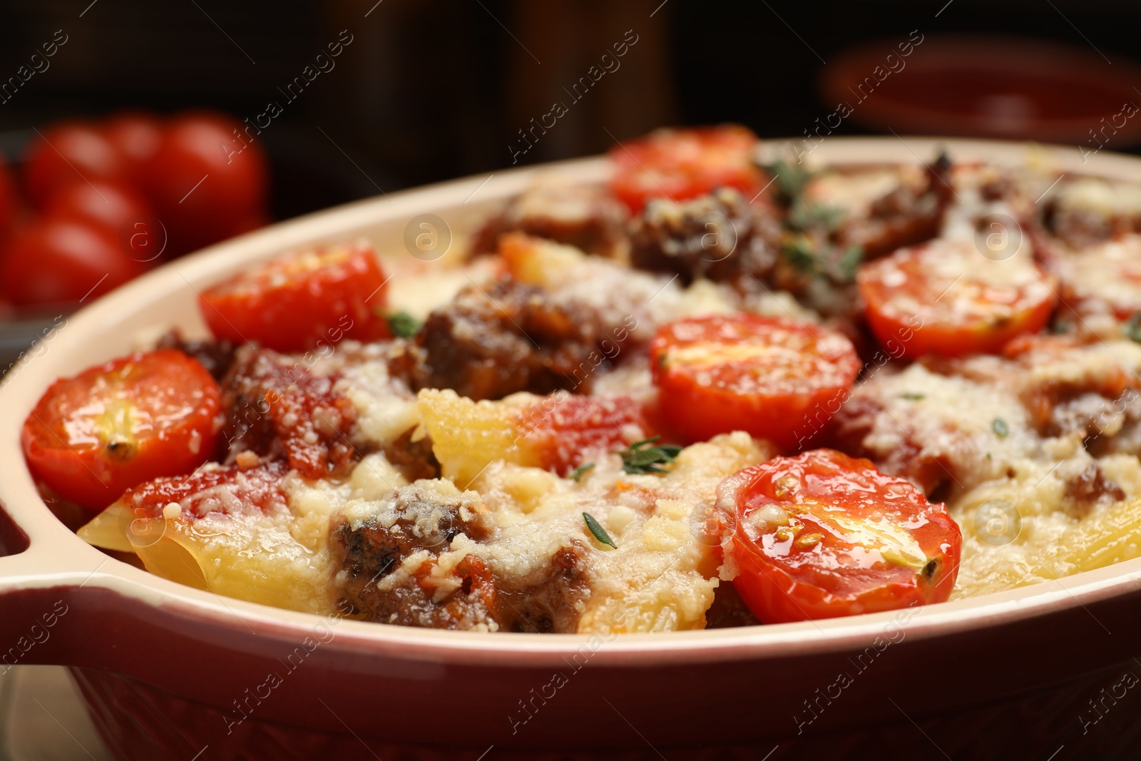 Photo of Delicious pasta casserole with cheese, tomatoes, minced meat and thyme in baking dish, closeup