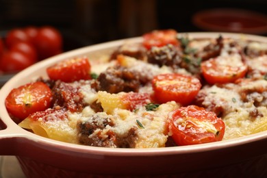 Photo of Delicious pasta casserole with cheese, tomatoes, minced meat and thyme in baking dish, closeup