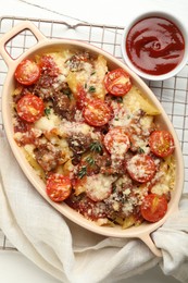 Photo of Delicious pasta casserole with cheese, tomatoes, minced meat and ketchup on white table, flat lay