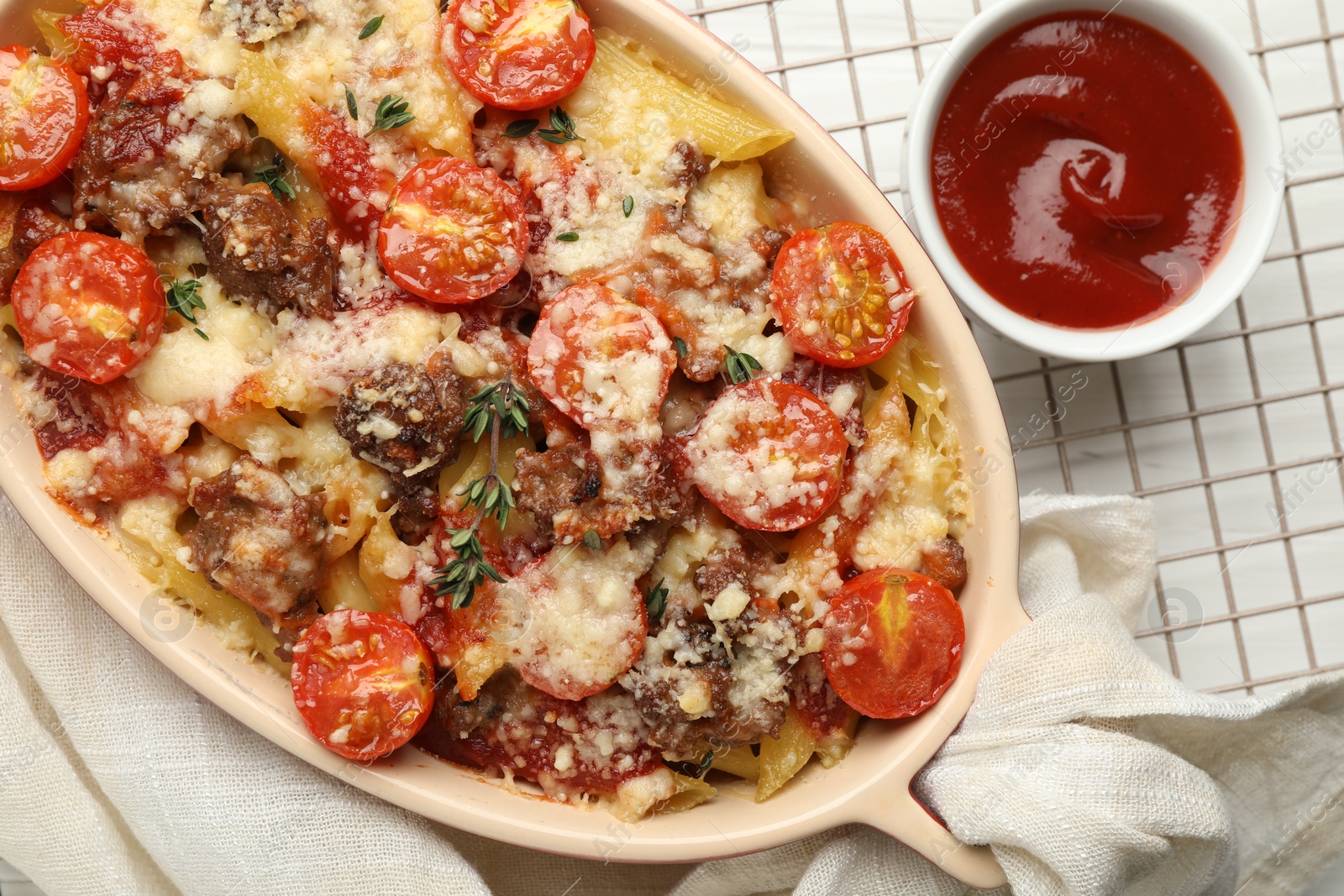 Photo of Delicious pasta casserole with cheese, tomatoes, minced meat and ketchup on white table, flat lay