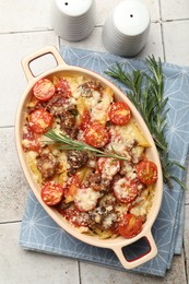 Photo of Delicious pasta casserole in baking dish, rosemary and spices on tiled table, flat lay