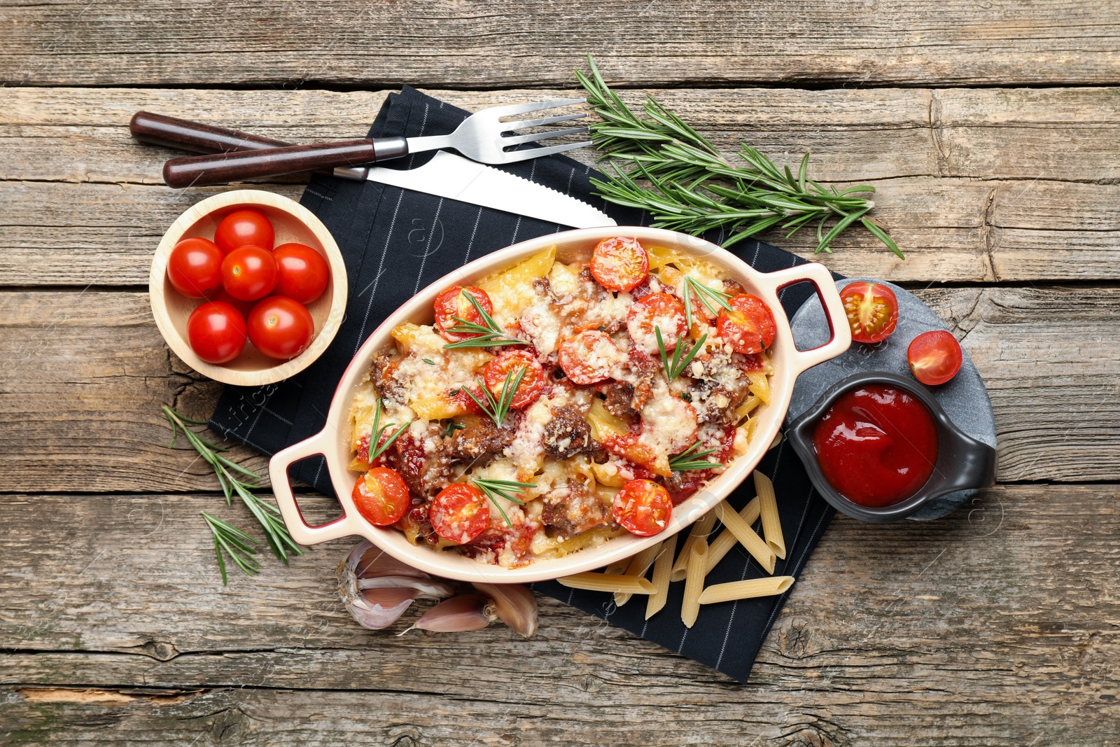 Photo of Flat lay composition with delicious pasta casserole in baking dish on wooden table