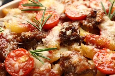 Photo of Delicious pasta casserole with cheese, tomatoes, minced meat and rosemary, closeup